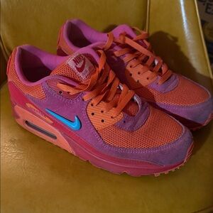 Nike pink and orange Air Max sneakers with blue Swoosh